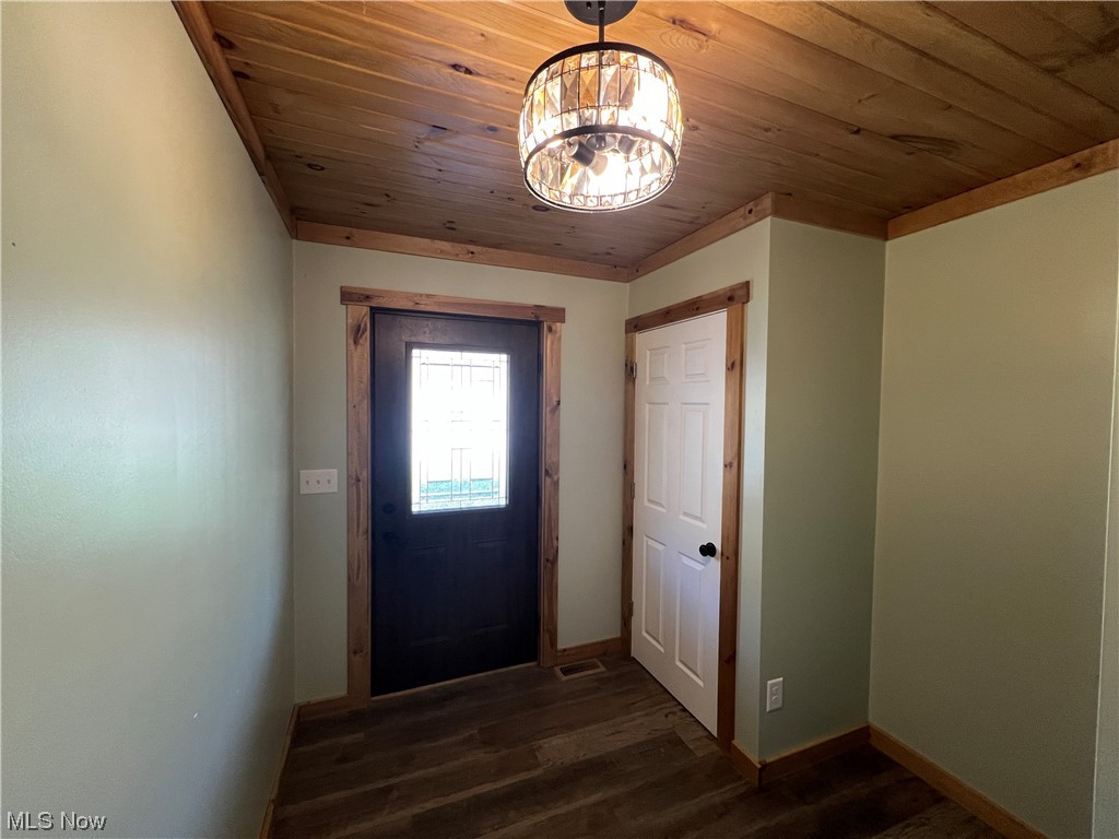 6544 Middle Run Road Dover, OH 44622 - Photo 23 of 47 Doorway featuring an inviting chandelier, dark hardwood / wood-style floors, and wood ceiling