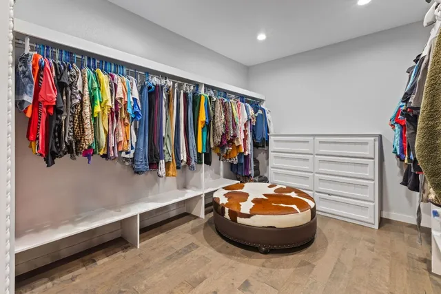 a view of walk in closet with clothes and shoes