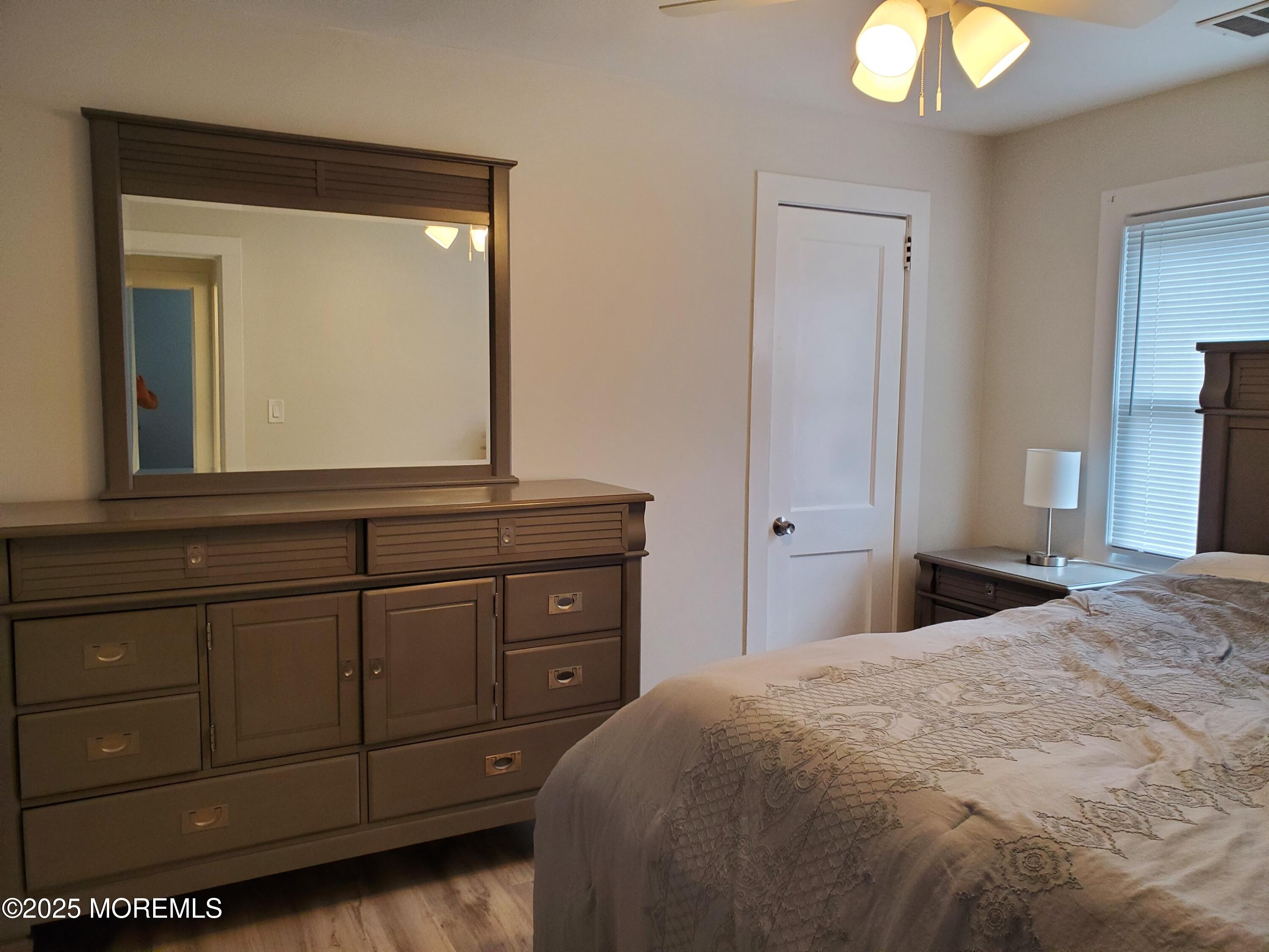 115 Dupont Avenue, Unit C Seaside Heights, NJ 08751 - Photo 5 of 6 a bedroom with a bed and a mirror on dresser