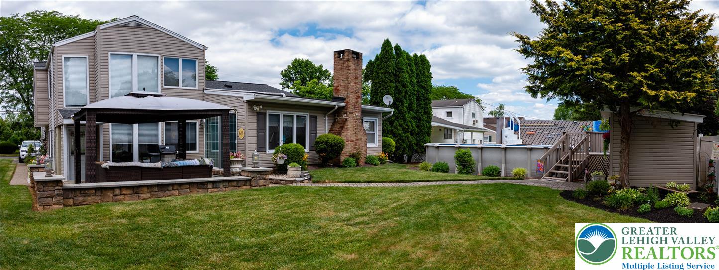 2087 Hopewell Road Bethlehem, PA 18017 - Photo 34 of 38 A private backyard oasis with an above-ground pool, expansive green lawn, and charming patio seating.