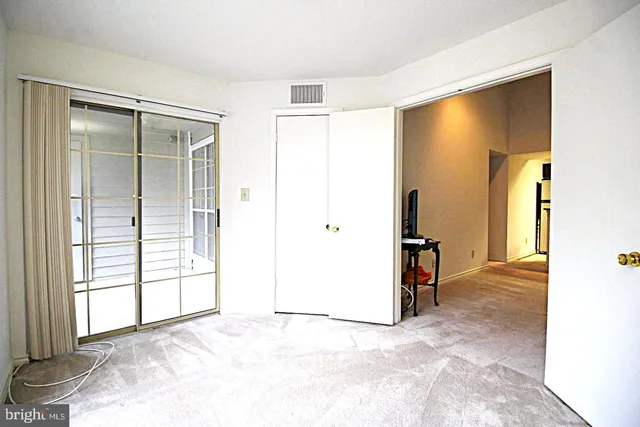 an empty room with windows and closet
