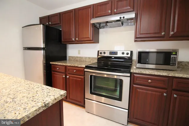 a kitchen with stainless steel appliances granite countertop a stove microwave and cabinets