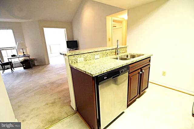 a en suite bathroom with a granite countertop sink and a mirror