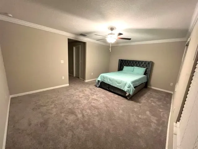 a spacious bedroom with a bed and a chandelier