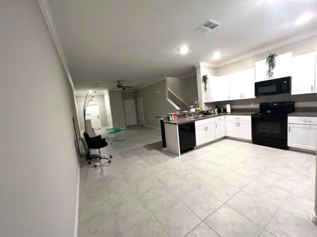 a kitchen with stainless steel appliances kitchen island granite countertop a stove and a sink