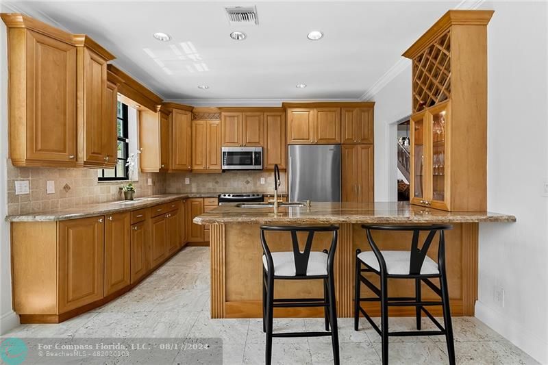 23285 Mirabella Circle Boca Raton, FL 33433 - Photo 12 of 31 a kitchen with stainless steel appliances granite countertop wooden cabinets a dining table and chairs