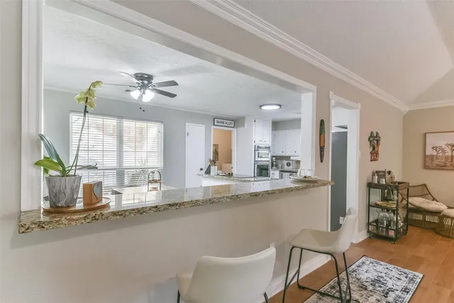 a large kitchen with kitchen island a large window a sink and chairs