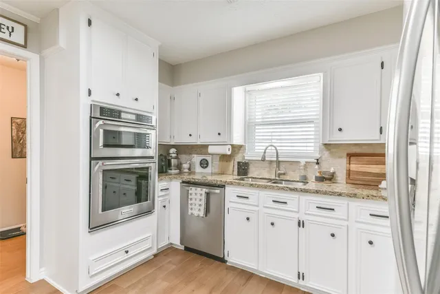 a kitchen with stainless steel appliances granite countertop a stove a sink and a microwave