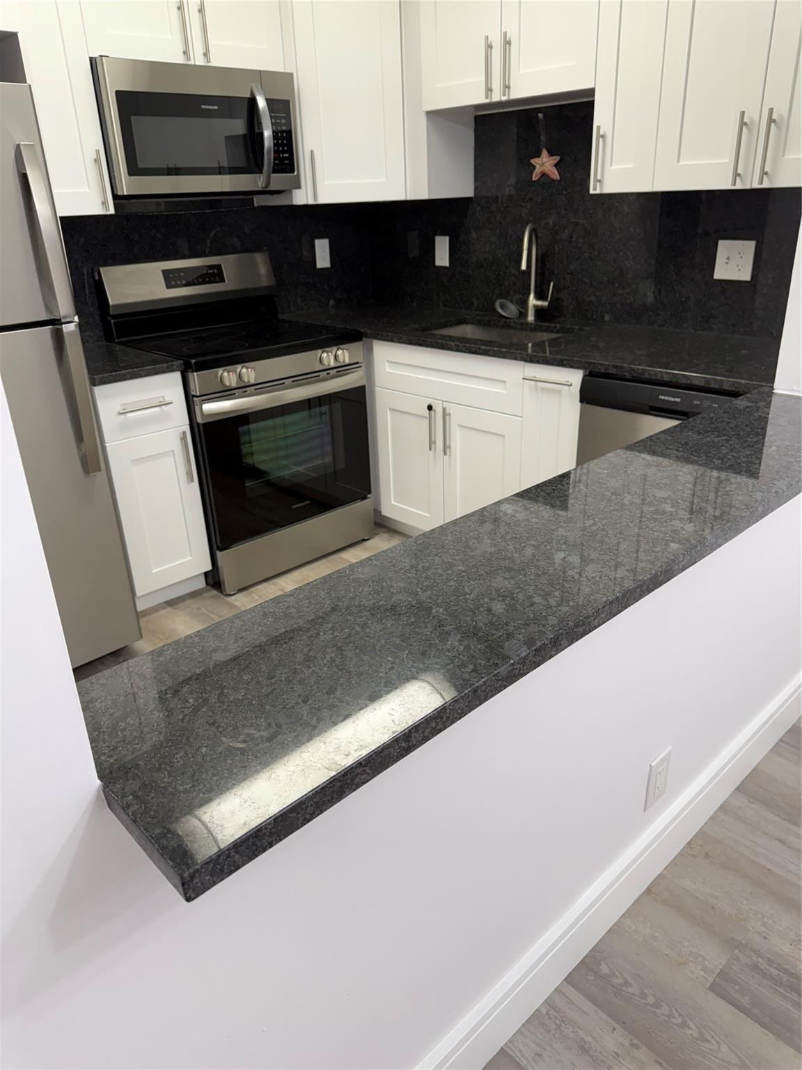 255 South Cypress Road, Unit 323 Pompano Beach, FL 33060 - Photo 1 of 11 a kitchen with granite countertop a stove and a microwave