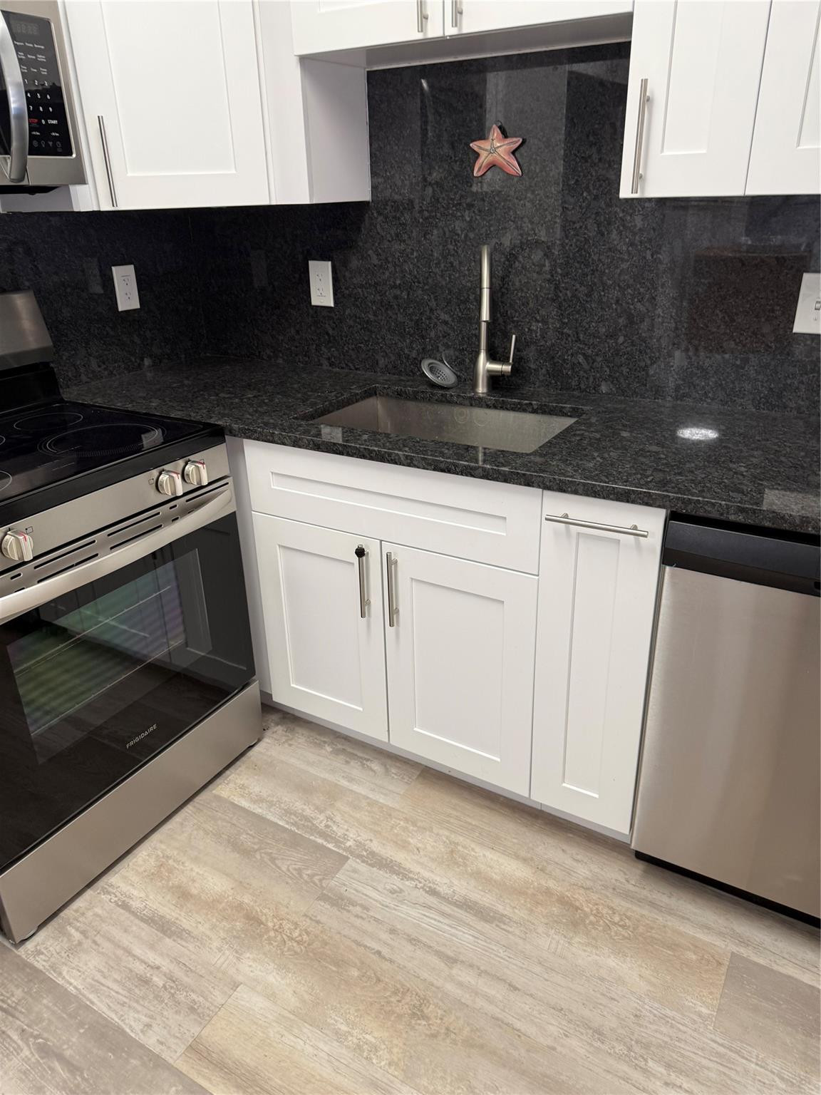 255 South Cypress Road, Unit 323 Pompano Beach, FL 33060 - Photo 2 of 11 a kitchen with granite countertop white cabinets and black appliances
