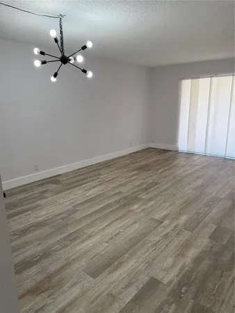 a view of a room with wooden floor and fan