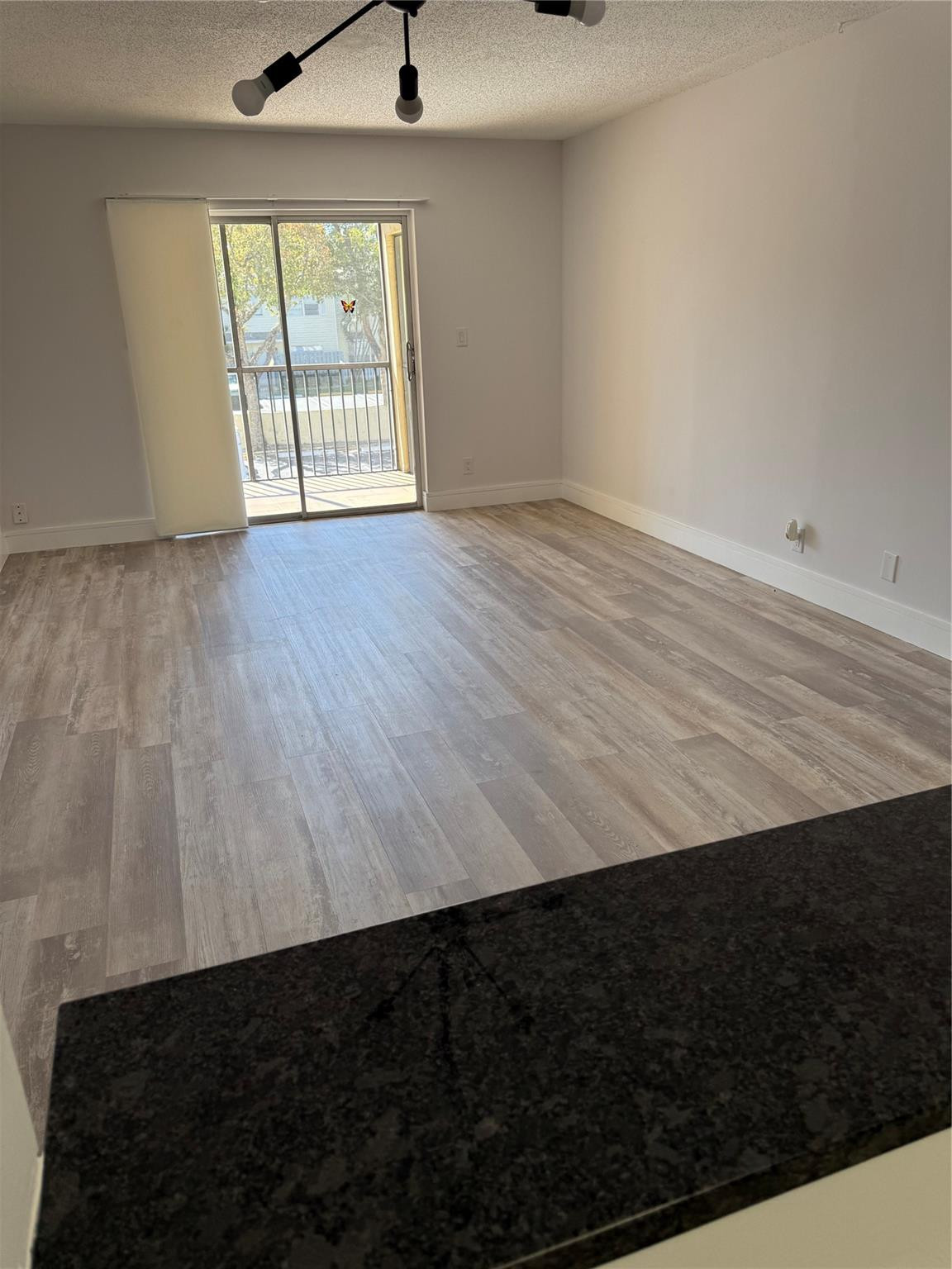 255 South Cypress Road, Unit 323 Pompano Beach, FL 33060 - Photo 5 of 11 wooden floor in an empty room with a window