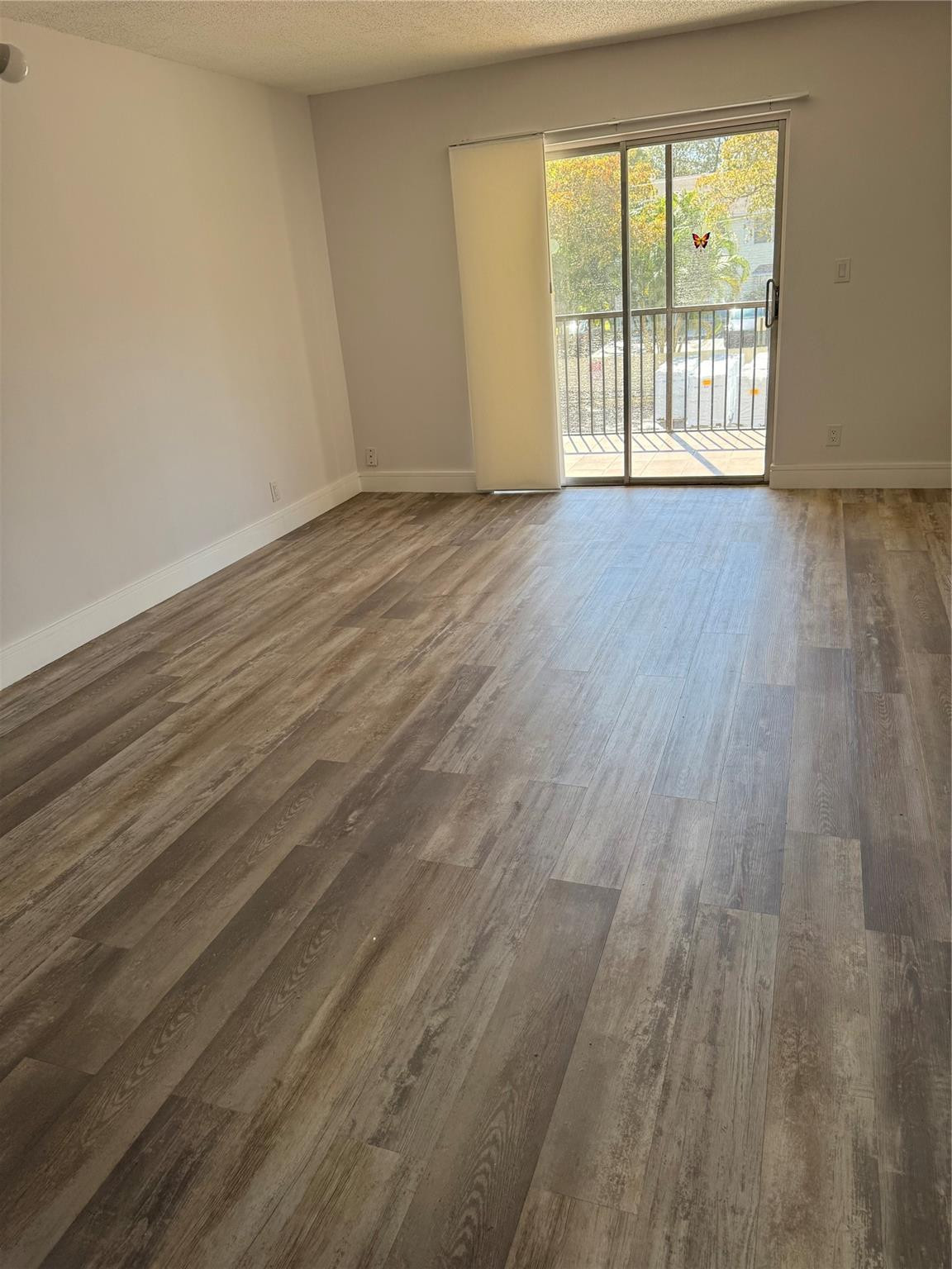 255 South Cypress Road, Unit 323 Pompano Beach, FL 33060 - Photo 8 of 11 a view of an empty room with wooden floor and a window