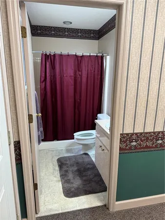 a bathroom with a toilet and a shower