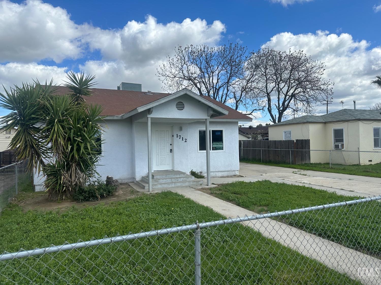 a front view of a house with a garden and yard