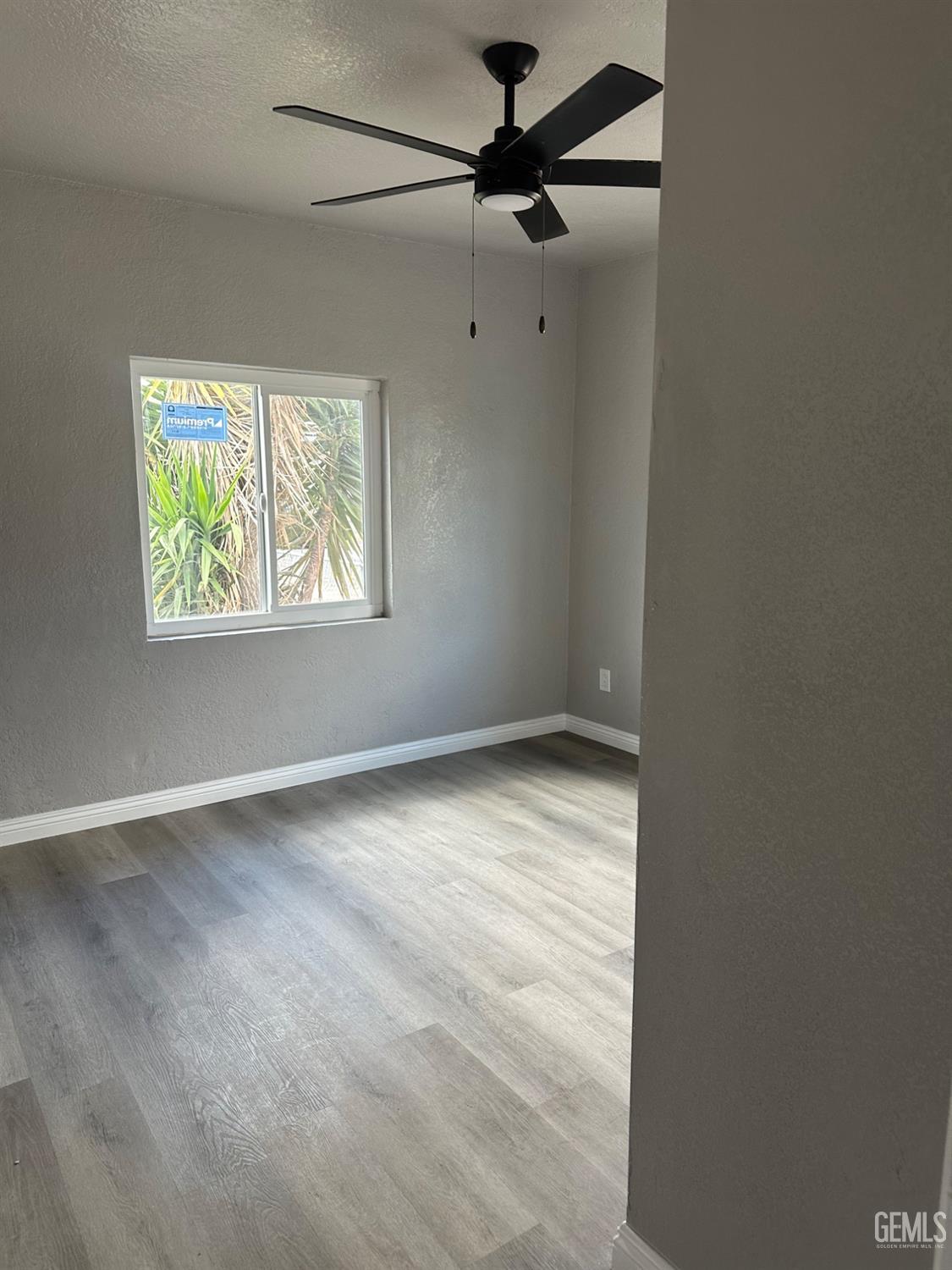 Undisclosed Address Delano, CA 93215 - Photo 6 of 13 an empty room with windows and fan