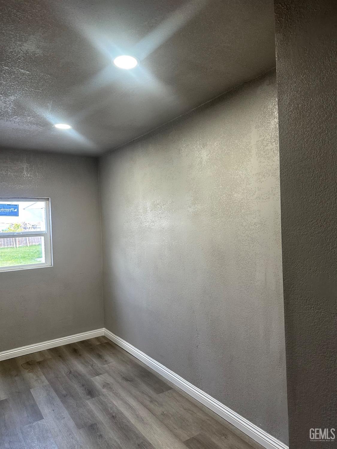 Undisclosed Address Delano, CA 93215 - Photo 9 of 13 an empty room with wooden floor and windows