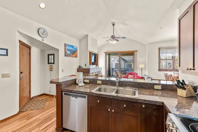 a kitchen with granite countertop a sink cabinets and wooden floor