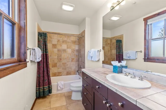 a bathroom with a granite countertop sink toilet a mirror and shower