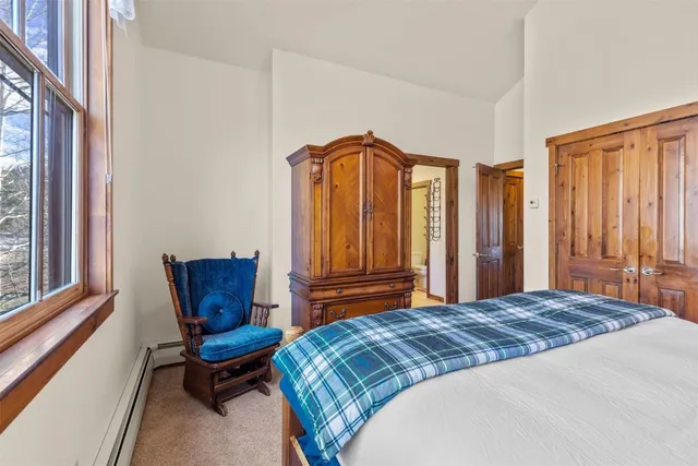 a bedroom with a chair and a window