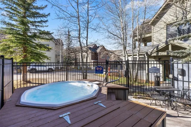 a balcony with wooden floor table and chairs