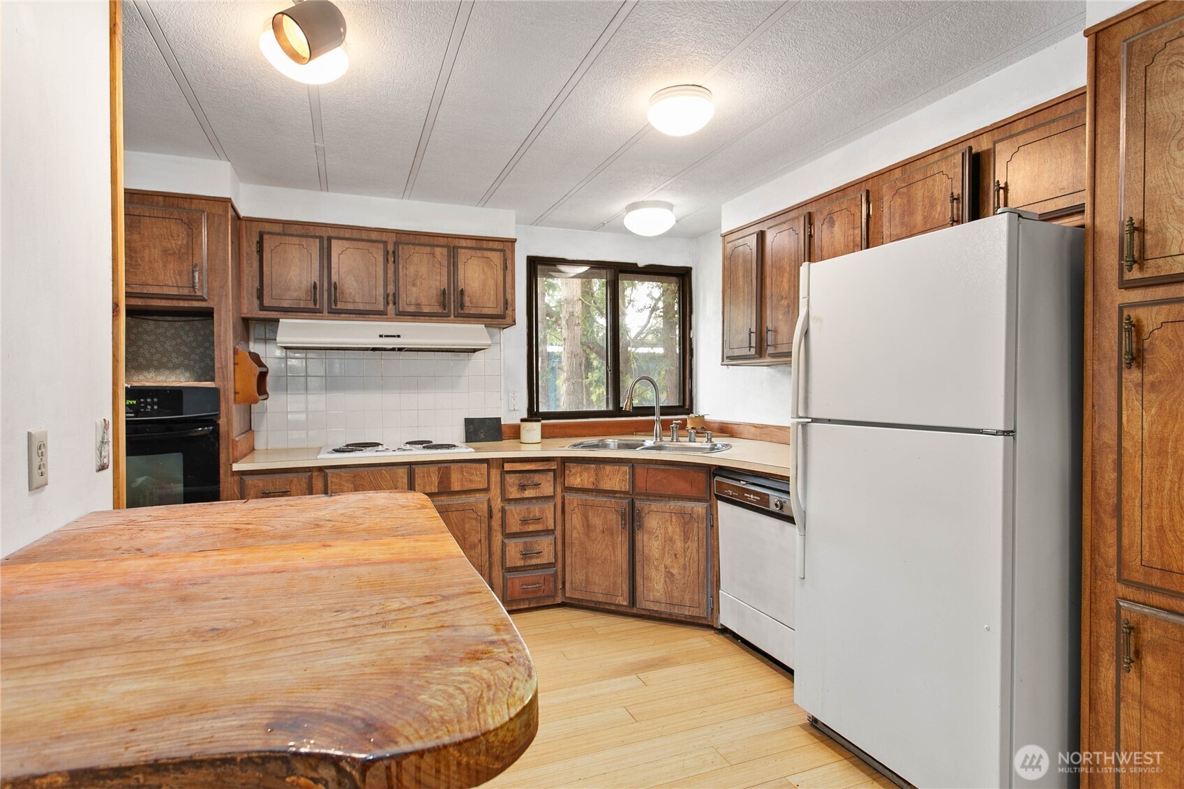 4015 Eliza Avenue, Unit 120 Bellingham, WA 98226 - Photo 11 of 26 a kitchen with kitchen island a counter top space a sink stainless steel appliances and cabinets
