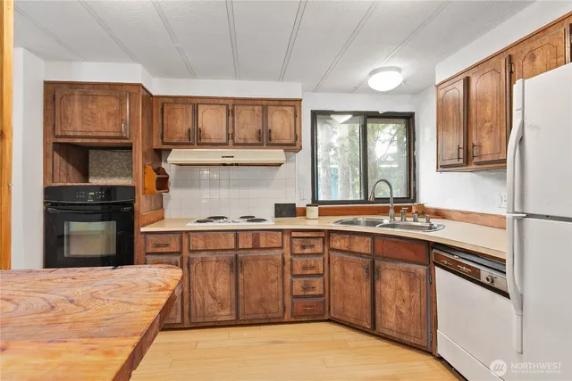 a kitchen with stainless steel appliances granite countertop a stove sink and cabinets