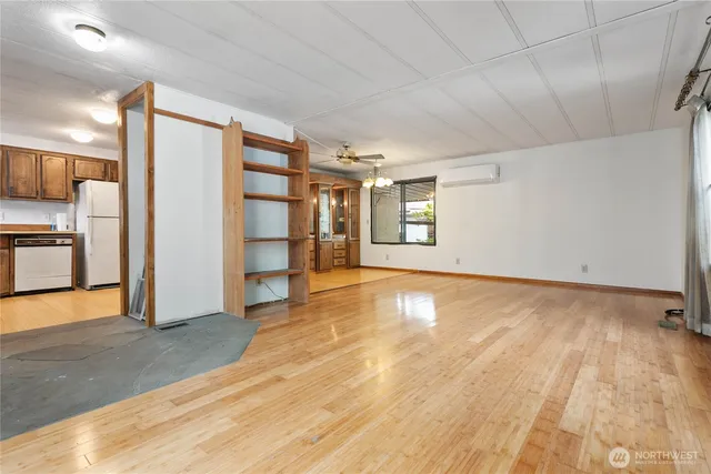 a view of empty room with wooden floor and window