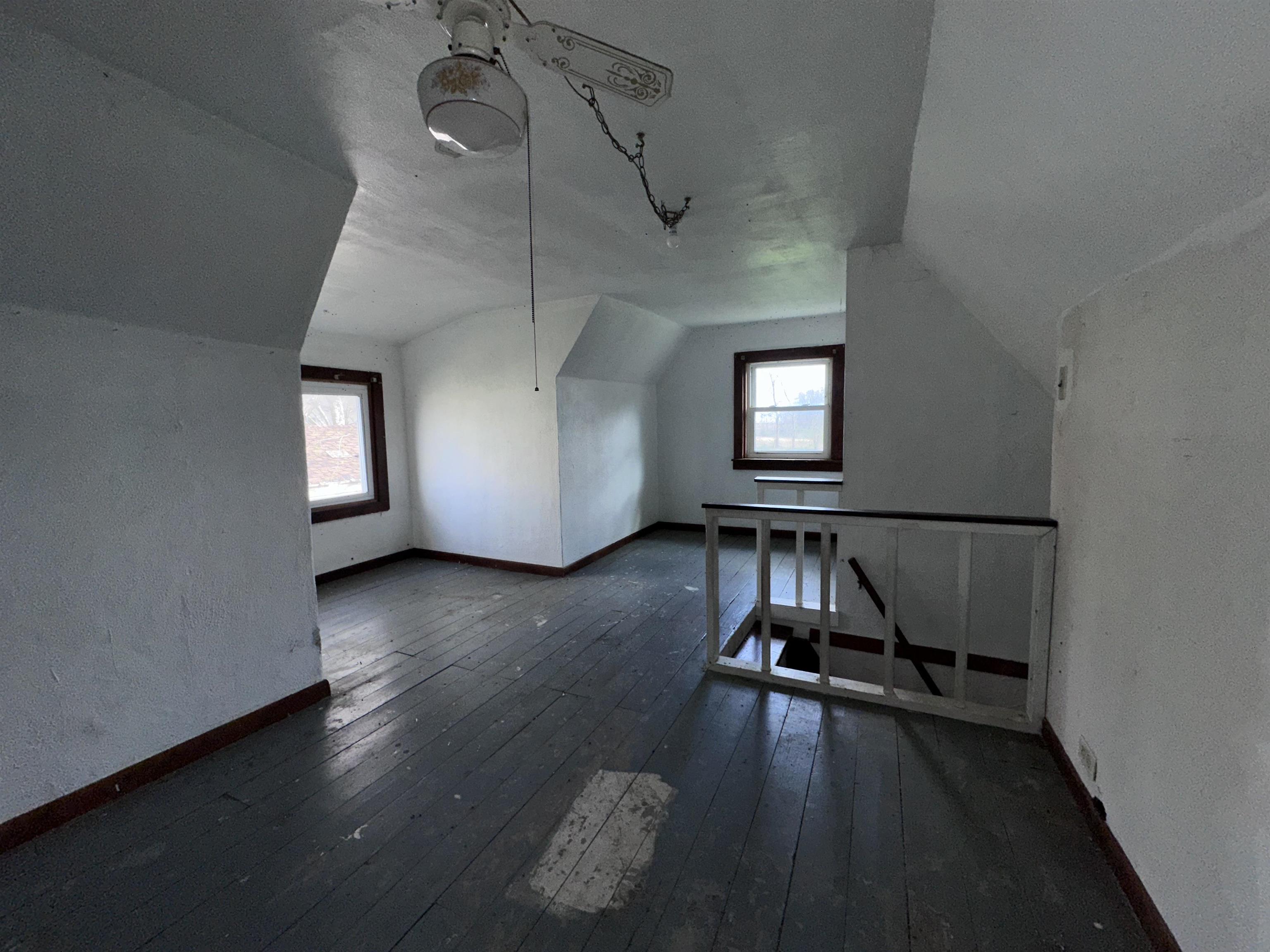 2855 West Florence Road Freeport, IL 61032 - Photo 10 of 13 an empty room with wooden floor a ceiling fan and windows