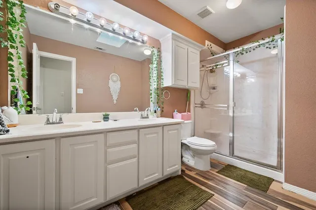 a bathroom with a double vanity sink mirror and toilet