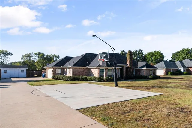 a view of a house with a big yard and large trees