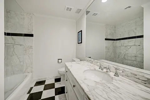 a bathroom with a granite countertop sink a toilet a shower and a mirror