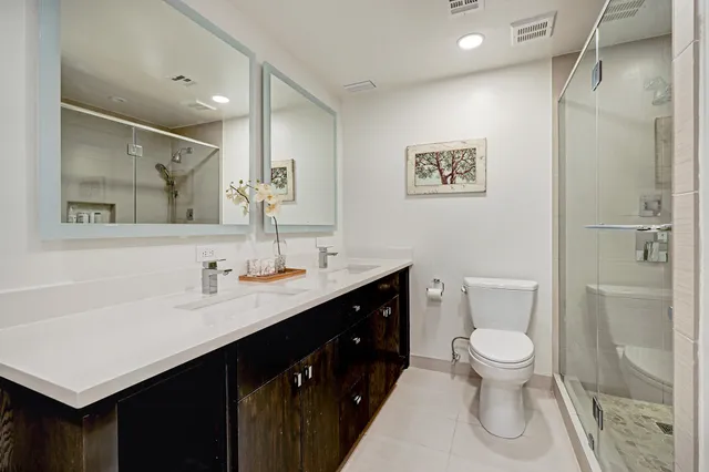 a bathroom with a toilet sink double vanity and mirror