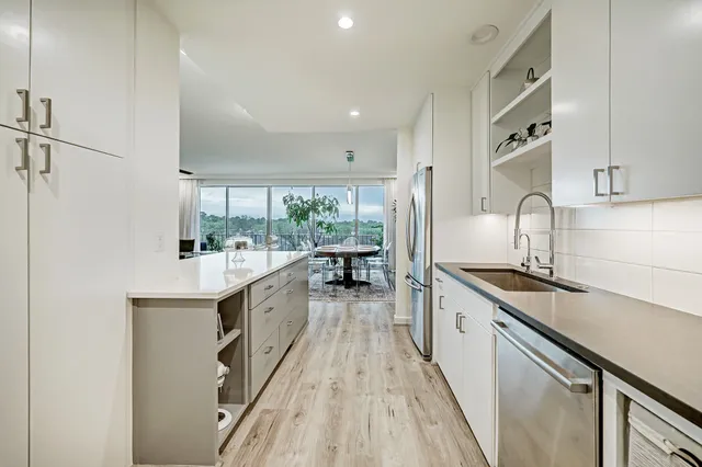 a kitchen with granite countertop a sink stove and cabinets
