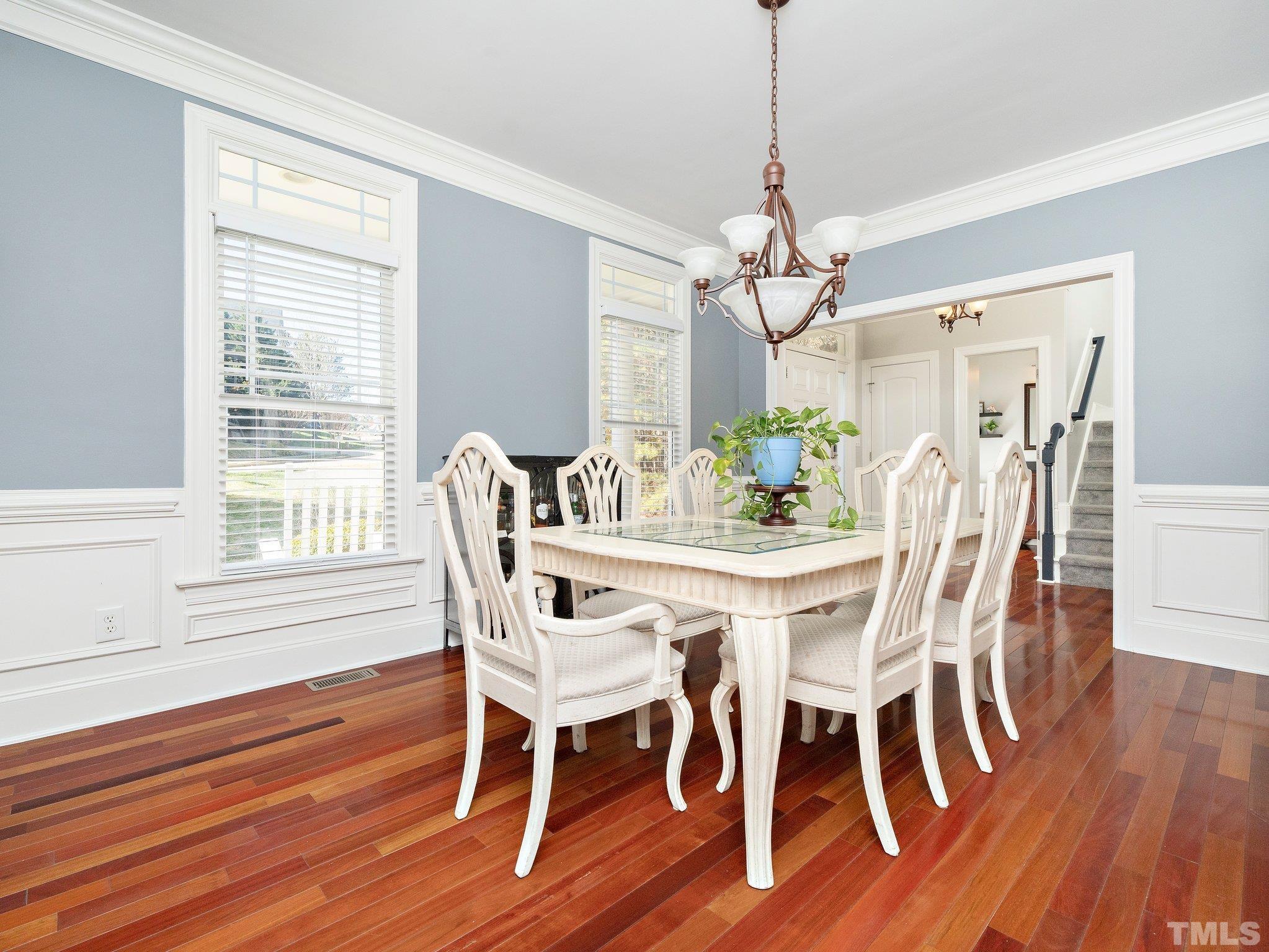 2717 Peachleaf Street Raleigh, NC 27614 - Photo 6 of 42 a dining room with wooden floor a chandelier a wooden table and chairs