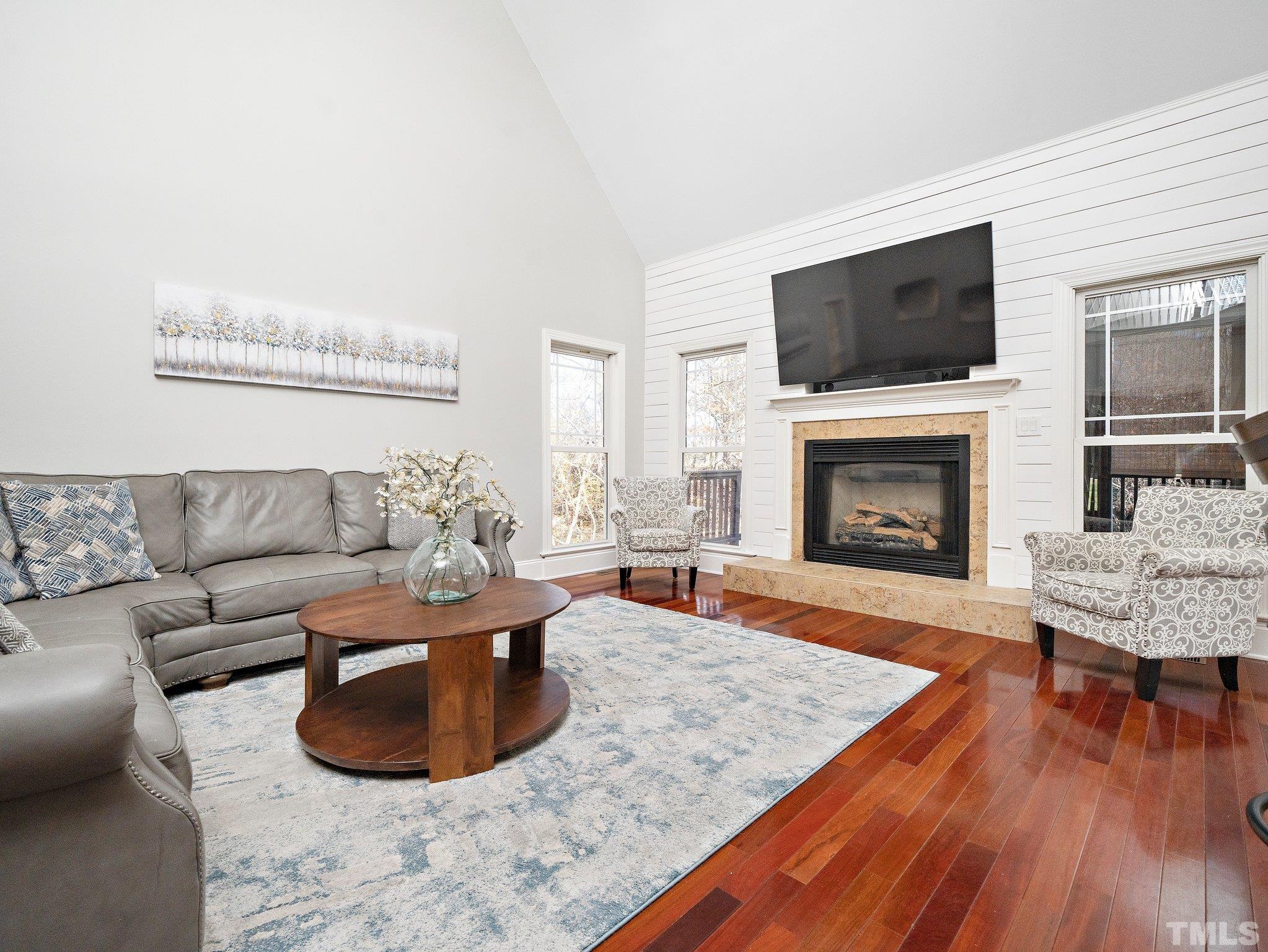 2717 Peachleaf Street Raleigh, NC 27614 - Photo 8 of 42 a living room with furniture a flat screen tv and a fireplace