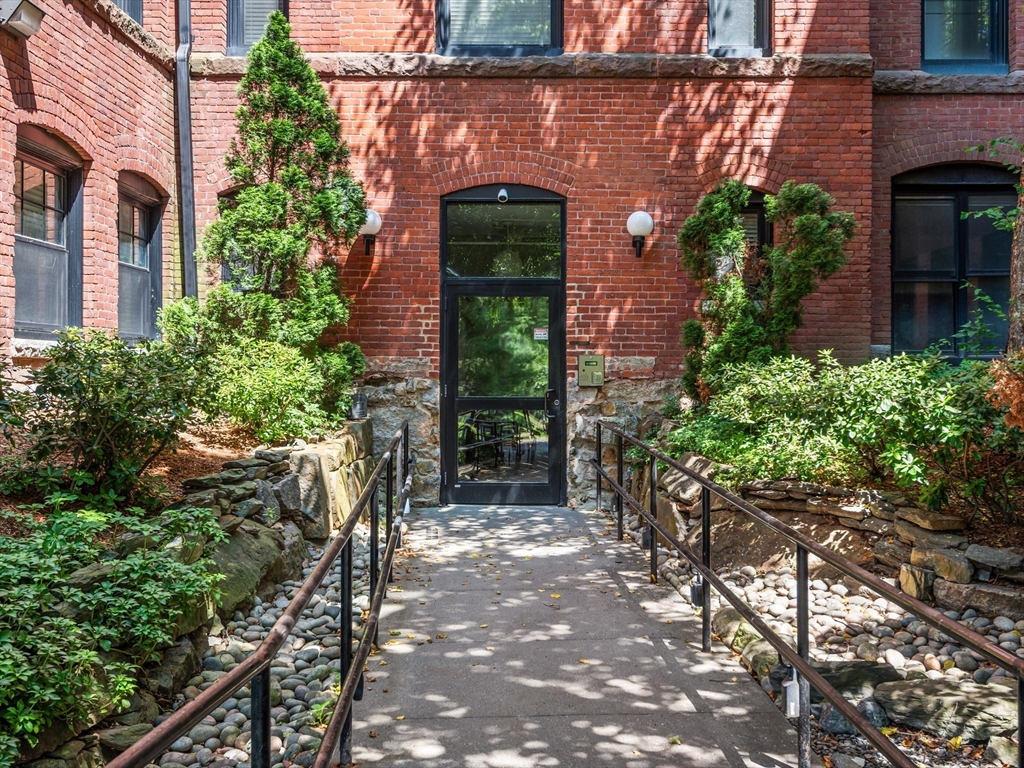 28 Adams Street, Unit 102 Worcester, MA 01604 - Photo 24 of 34 a front view of a house with a lots of potted plants