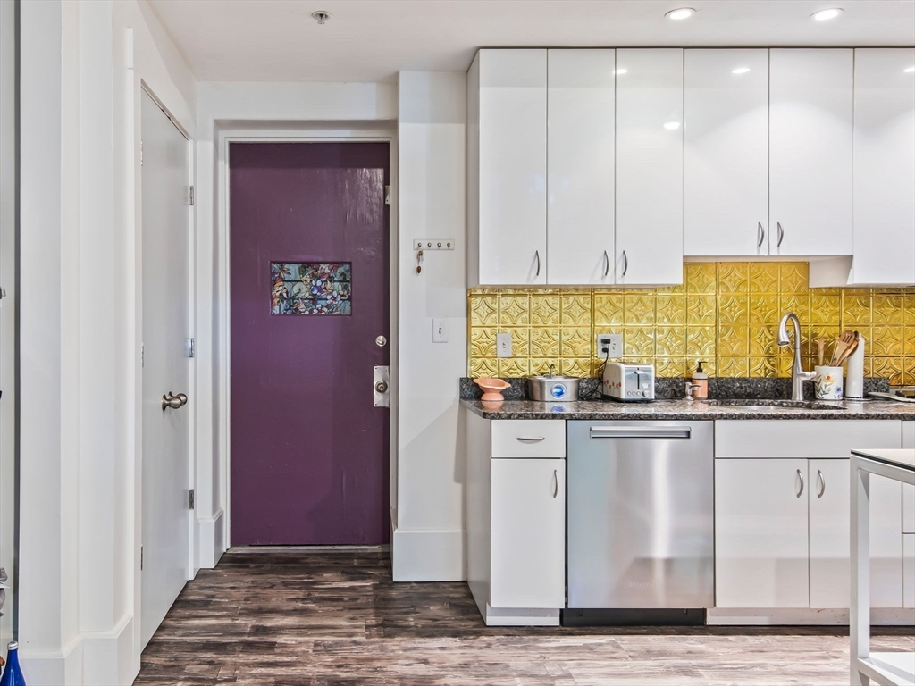28 Adams Street, Unit 102 Worcester, MA 01604 - Photo 5 of 34 a kitchen with stainless steel appliances granite countertop a coffee maker a sink and a refrigerator