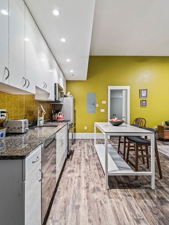 28 Adams Street, Unit 102 Worcester, MA 01604 - Photo 7 of 34 a kitchen with stainless steel appliances granite countertop a sink stove and cabinets