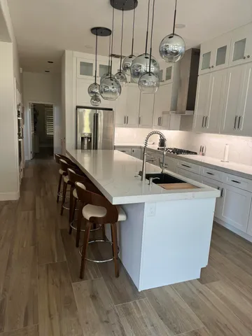 a kitchen with stainless steel appliances granite countertop a sink a stove and chairs