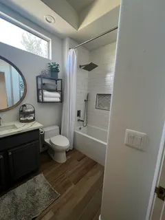 a bathroom with a granite countertop sink toilet a mirror and shower