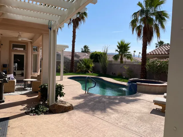a view of swimming pool with a patio and a yard