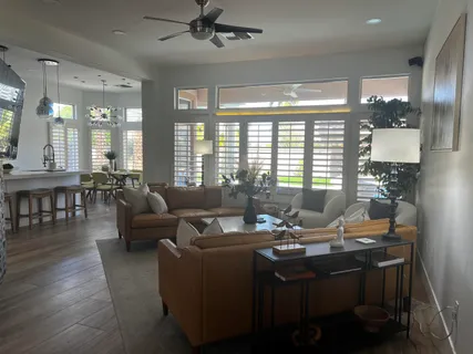 a living room with furniture and floor to ceiling windows