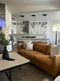 a living room with furniture kitchen view and a potted plant