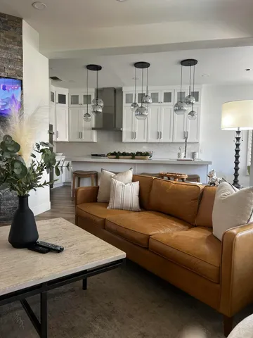 a living room with furniture kitchen view and a potted plant