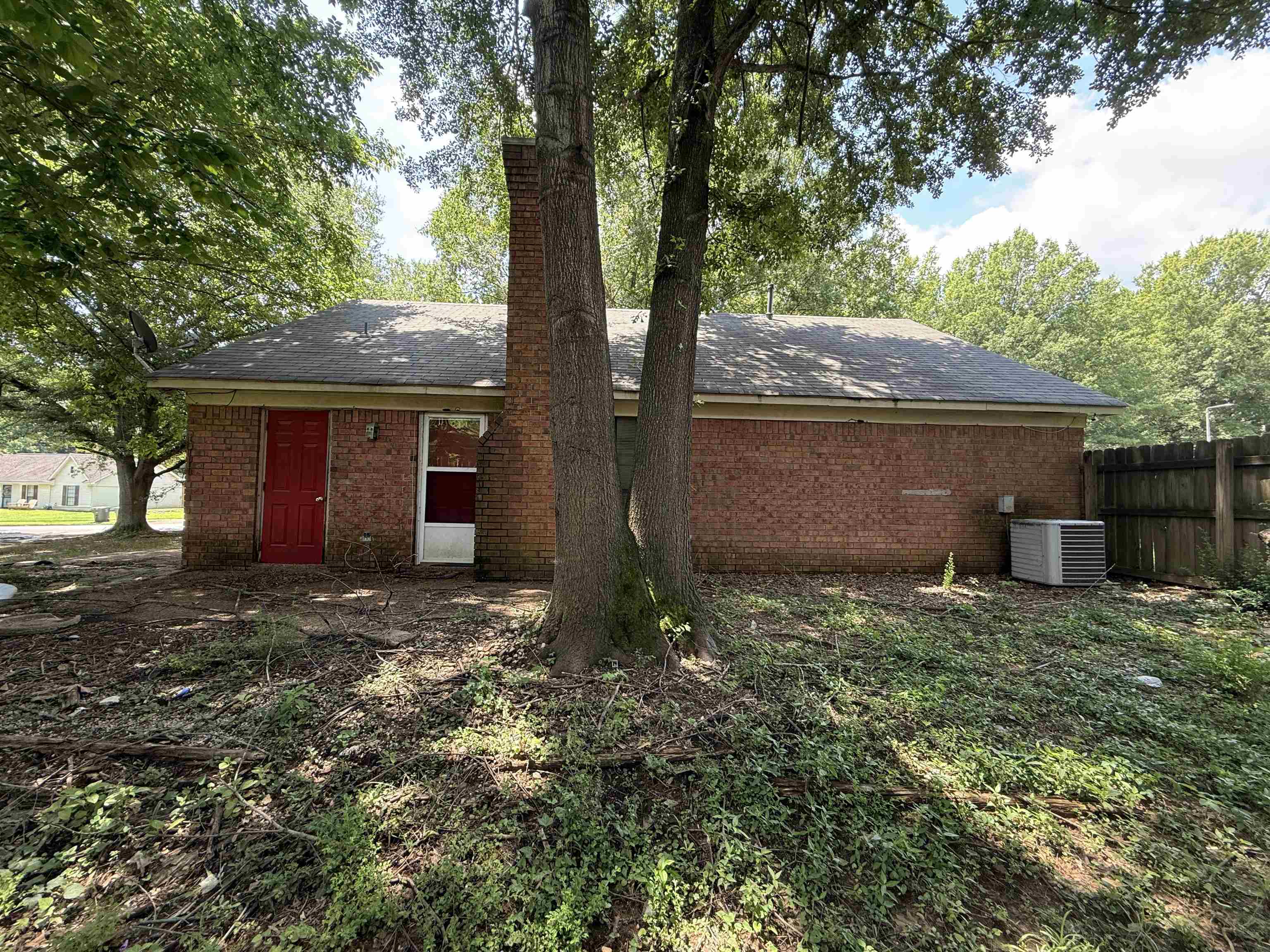 6420 Saginaw Road Memphis, TN 38134 - Photo 38 of 38 Brick exterior with a red entry door, white screen door, and a prominent brick chimney