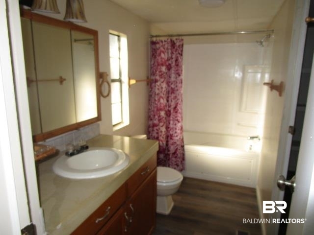14791 Raber Road Summerdale, AL 36580 - Photo 13 of 21 Full bathroom with vanity, shower / bath combination with curtain, toilet, and wood-type flooring
