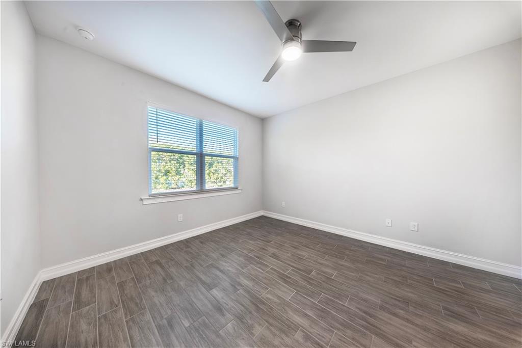 1059 Enbrook Loop Naples, FL 34114 - Photo 13 of 40 Unfurnished room featuring wood finish floors and a ceiling fan