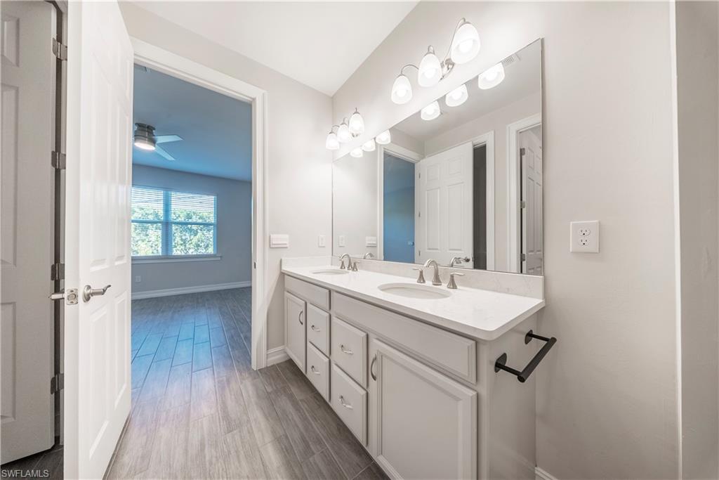 1059 Enbrook Loop Naples, FL 34114 - Photo 16 of 40 Full bathroom with double vanity, dark wood-style flooring, and a ceiling fan