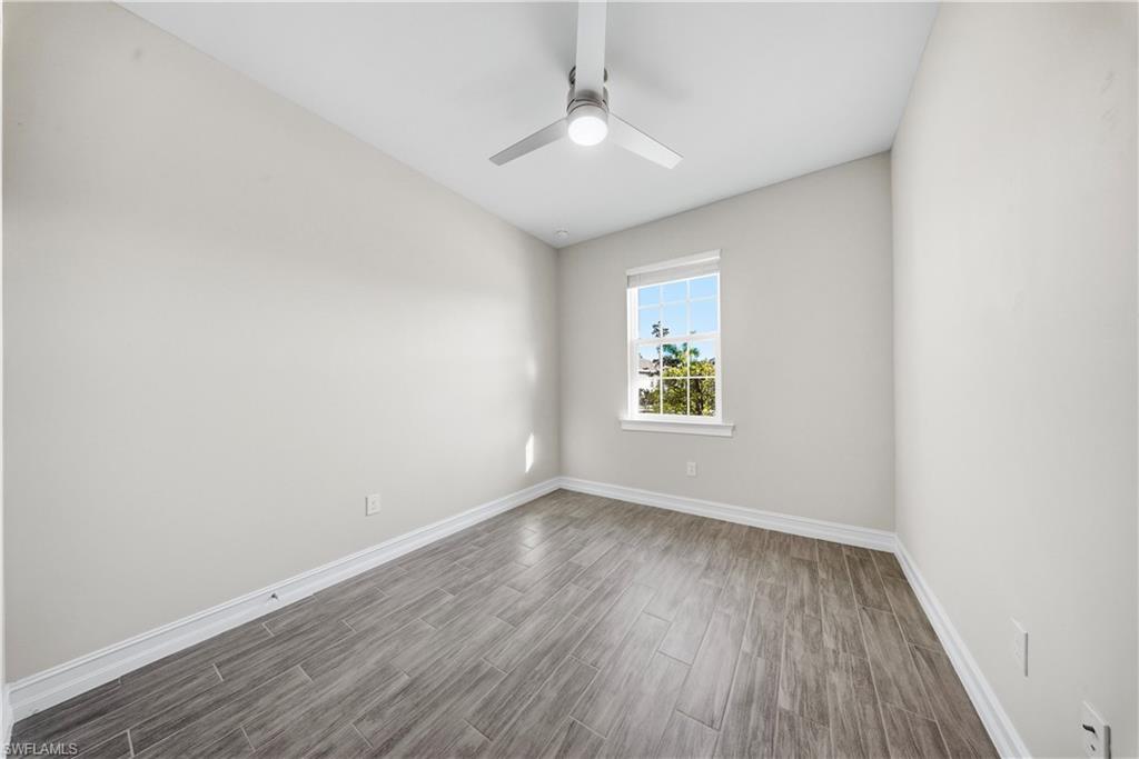 1059 Enbrook Loop Naples, FL 34114 - Photo 21 of 40 Unfurnished room with wood tiled floors and a ceiling fan